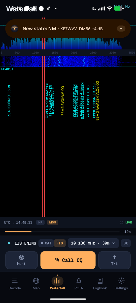 FT8AF の Waterfall タブ：デコードされたコールサインが信号上に縦に刻まれたフルバンドのスペクトログラム、TX 周波数マーカー、UTC タイムスタンプ、そして 'New state: NM · KE7WVV DM56 −4 dB' と表示されるアクティブ QSO 状態バナー。